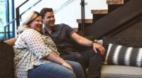 man and woman sitting on sofa smiling