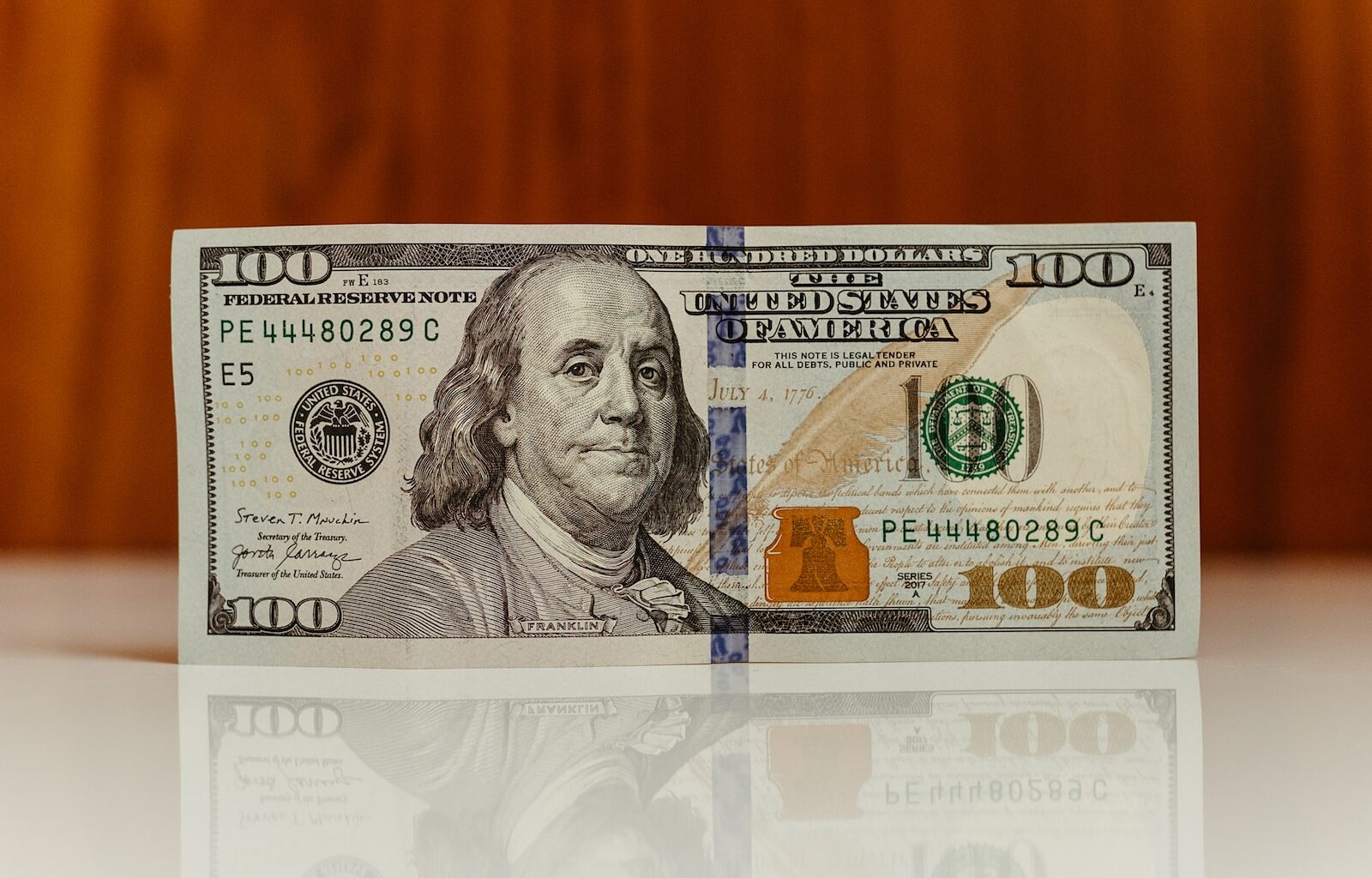 a one hundred dollar bill sitting on top of a table