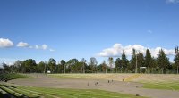 Escenario al aire libre del Parque Simón Bolívar de Bogotá, con gradas verdes y árboles al fondo