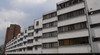 Bloque de apartamentos de varios pisos con ventanas y garajes en planta baja