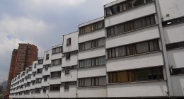 Bloque de apartamentos de varios pisos con ventanas y garajes en planta baja