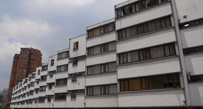 Bloque de apartamentos de varios pisos con ventanas y garajes en planta baja