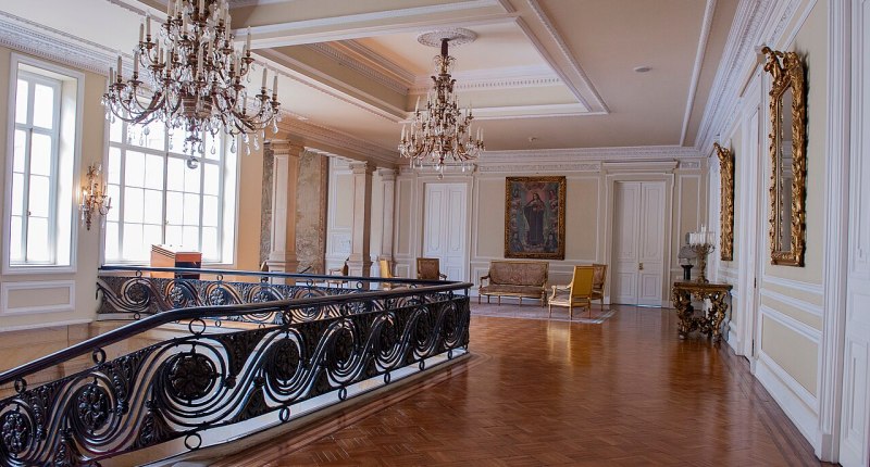 Salón interior de la Casa de Nariño, con lámparas de cristal, muebles antiguos y pisos de madera