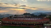 Estadio Palogrande de Manizales al atardecer, con graderías vacías y la cancha de césped