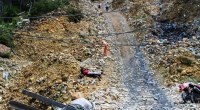 Mina de oro artesanal en Marmato (Caldas), con una mula cargando una viga entre rocas y casas al fondo (foto de archivo)