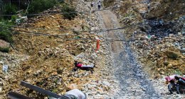 Mina de oro artesanal en Marmato (Caldas), con una mula cargando una viga entre rocas y casas al fondo (foto de archivo)