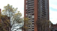 Torre residencial de ladrillo con balcones, en una avenida de Bogotá