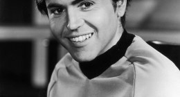 Walter Koenig sonriendo en blanco y negro, con el uniforme de la Flota Estelar de Star Trek