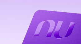 Tarjeta de crédito morada de Nu con el logo en relieve, sobre fondo lila