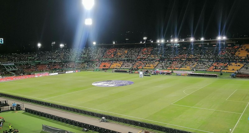 Vista nocturna del Estadio Atanasio Girardot de Medellín con la tribuna llena de hinchas durante un partido