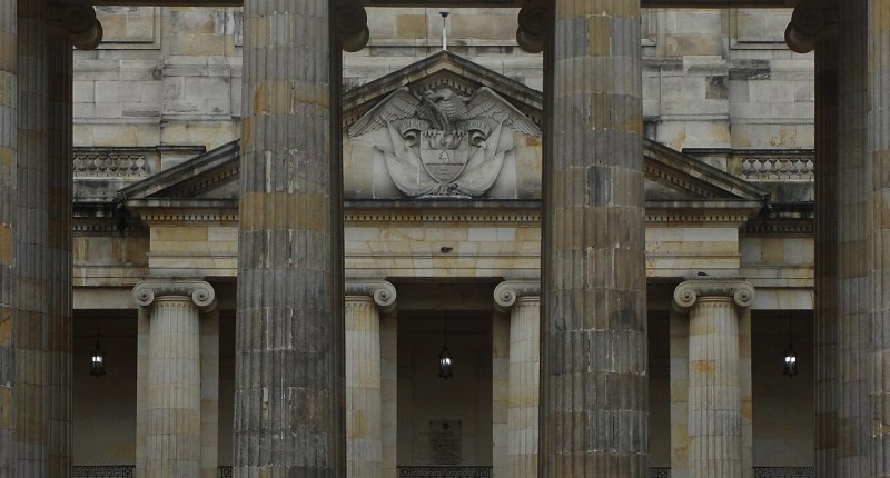 Columnas jónicas del Capitolio Nacional de Bogotá, sede del Congreso, con la estatua de un prócer al fondo