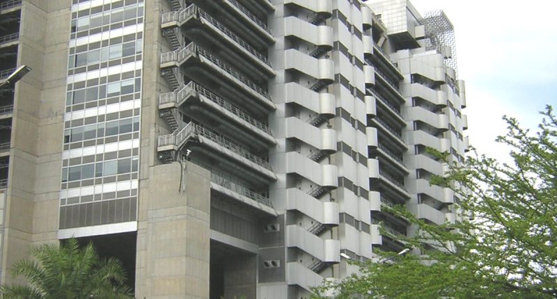 Fachada este del Edificio EPM en Medellín, edificio de concreto con balcones y árboles en la acera