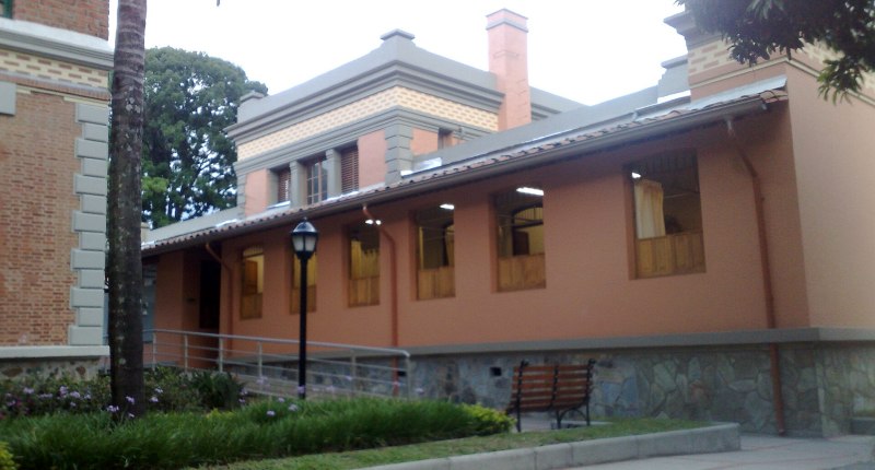 Edificio de un hospital con fachada color terracota y ventanas de madera, sin personas