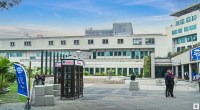 Fachada de la sede de la Fiscalía en Bogotá, con una caseta con el nombre de la entidad y la plaza en primer plano