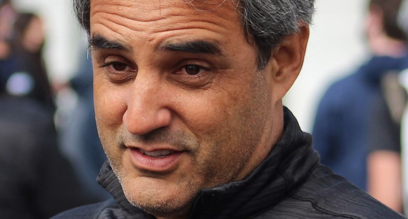 Retrato de Juan Pablo Montoya con chaqueta gris del equipo Arrow McLaren, de perfil y hablando