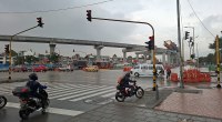 Viaducto del metro de Bogotá en obra sobre una avenida con semáforos, buses y motos