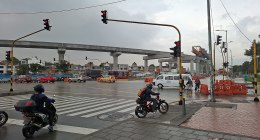 Viaducto del metro de Bogotá en obra sobre una avenida con semáforos, buses y motos
