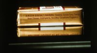 Cajetilla de cigarrillos de lado, sobre fondo oscuro, con la advertencia sanitaria impresa