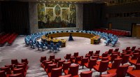 Sala del Consejo de Seguridad de la ONU en Nueva York, vacía, con las sillas rojas y azules y un mural al fondo