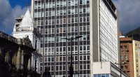 Fachada de torre de oficinas del Banco de la República en Bogotá, con la plaza y transeúntes al frente
