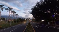 Autopista del Café a su paso por Armenia, Quindío, con palmas y tráfico al atardecer