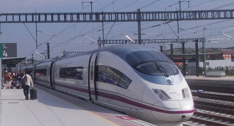 Tren AVE de Renfe, de color plata y morado, en un andén de estación