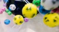 Bolas de lotería numeradas de colores girando dentro de una máquina transparente