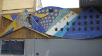 Mural de mosaico azul y amarillo con estrellas y un futbolista, junto a La Bombonera en Buenos Aires