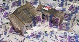 Fajos de billetes colombianos de 50.000 pesos, con las caras morada de los billetes sobre una mesa