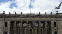 Fachada de columnas del Capitolio Nacional en Bogotá, con palomas en el cielo