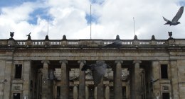 Fachada de columnas del Capitolio Nacional en Bogotá, con palomas en el cielo