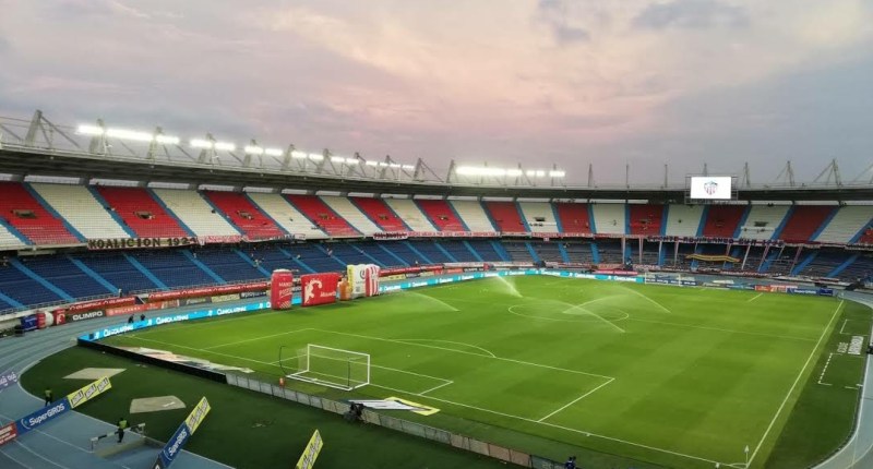 Estadio Metropolitano Roberto Meléndez de Barranquilla, con el campo iluminado y las gradas de colores al atardecer