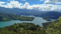 Embalse del Guavio visto desde una colina, con montañas verdes y nubes