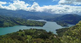 Embalse del Guavio visto desde una colina, con montañas verdes y nubes