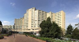 Fachada del Hospital Militar Central en Bogotá, edificio de varios pisos con jardines y un andén al frente