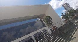 Edificio cultural de concreto y vidrio en Pereira, con escaleras y un edificio alto al fondo