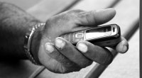 Mano sosteniendo un teléfono celular en blanco y negro