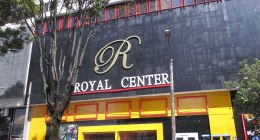 Fachada negra y amarilla del Royal Center en Bogotá, con su letrero dorado