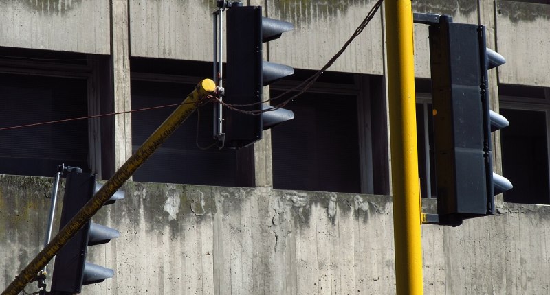Semáforos de una vía de Bogotá frente a un edificio de concreto