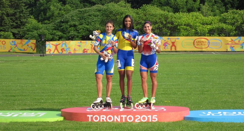 Podio de patinaje de velocidad femenino en Toronto 2015: una patinadora colombiana con medalla de oro, entre una ecuatoriana y una chilena