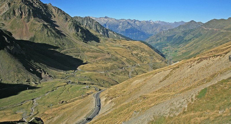 Carretera serpenteante que sube al Col du Tourmalet, en los Pirineos, con montañas al fondo