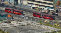 Buses articulados de TransMilenio circulando por una avenida de Bogotá, vistos desde arriba