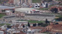 Vista aérea del estadio La Independencia de Tunja, con la cancha verde y la tribuna cubierta, rodeado de la ciudad
