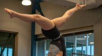 Gimnasta en equilibrio invertido sobre la barra de equilibrio