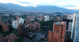 Vista aérea de edificios y montañas de Medellín al atardecer, desde El Poblado